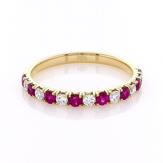 Gold ring with red gemstones and diamonds on a white background